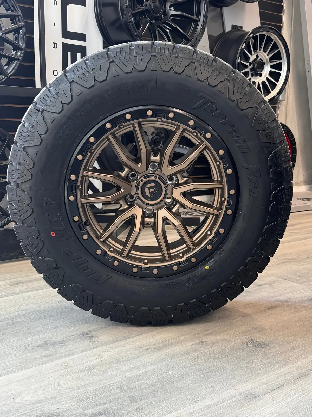 ( Set Of Four ) Fuel Rebel 18X9 +1 6X135 87.1 Matte Bronze Black Bead Ring | Lt 275/70R18 Amp Terrain Pro 1